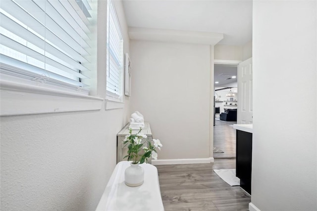 corridor with baseboards and wood finished floors