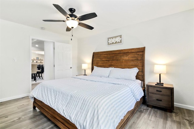 bedroom with a ceiling fan, baseboards, and wood finished floors