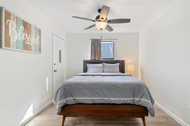bedroom with baseboards, ceiling fan, and light wood finished floors