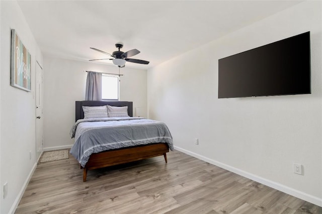 bedroom with baseboards, light wood finished floors, and ceiling fan