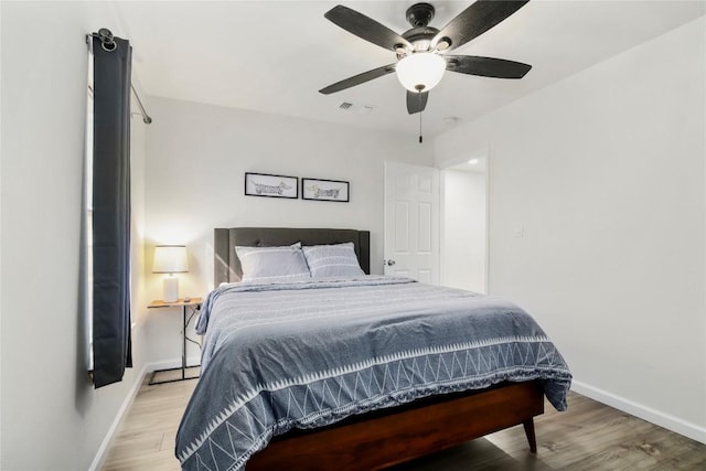 bedroom with baseboards, visible vents, ceiling fan, and light wood-style floors