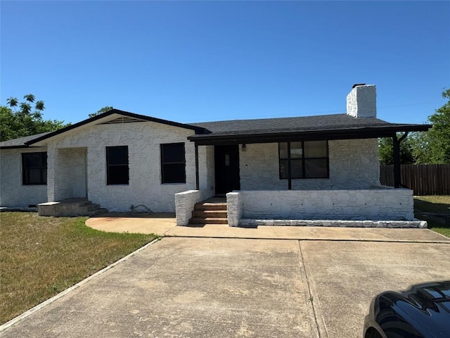 ranch-style house with fence, stone siding, roof with shingles, a chimney, and a porch
