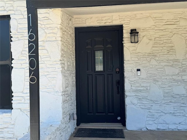 entrance to property featuring stone siding