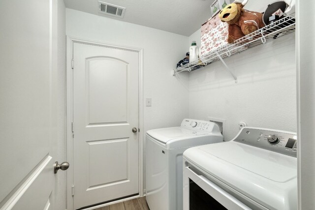 13029 Field Plow Ln, Elgin, TX 78621 - washroom with separate washer and dryer and wood finished floors