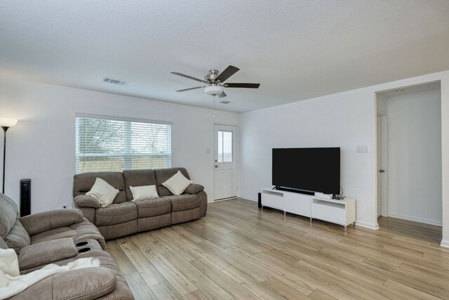 13029 Field Plow Ln, Elgin, TX 78621 - living room with light wood finished floors, ceiling fan, and baseboards