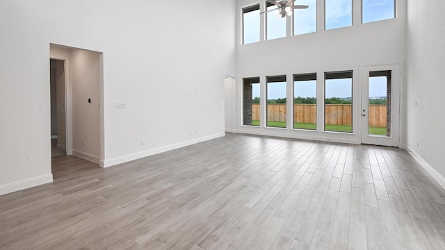 702 Bay Breeze Dr, Kyle, TX 78640 - unfurnished living room with a high ceiling, a ceiling fan, and light wood finished floors