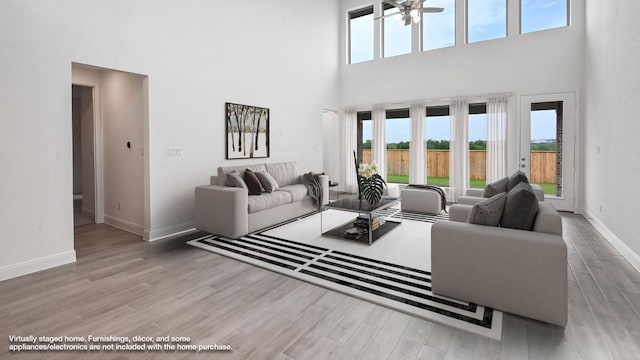702 Bay Breeze Dr, Kyle, TX 78640 - living room featuring a towering ceiling, wood finished floors, and a ceiling fan