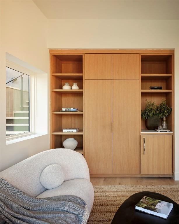 sitting room featuring built in shelves and light wood-type flooring