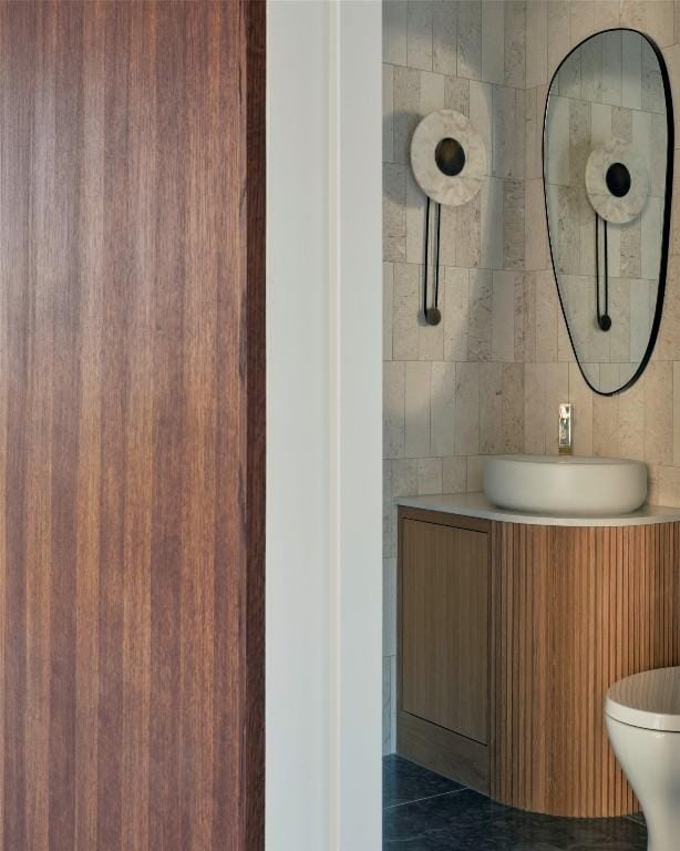 bathroom with toilet, tile walls, and vanity