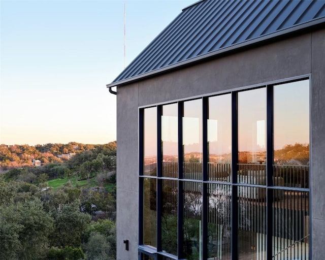 property exterior at dusk with a standing seam roof, metal roof, and stucco siding