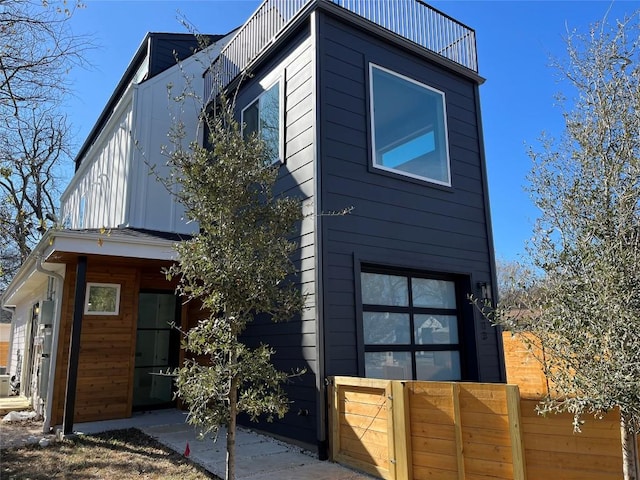 view of front of home featuring a balcony, fence, and board and batten siding