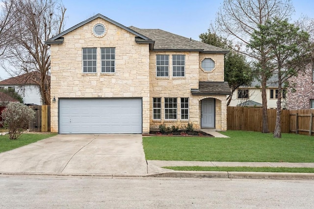 traditional home with a shingled roof, concrete driveway, an attached garage, a front yard, and fence