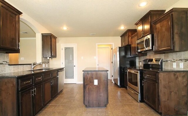 503 W Gemini Ln, Killeen, TX 76542 - kitchen with stainless steel appliances, a kitchen island, tasteful backsplash, dark brown cabinets, and recessed lighting