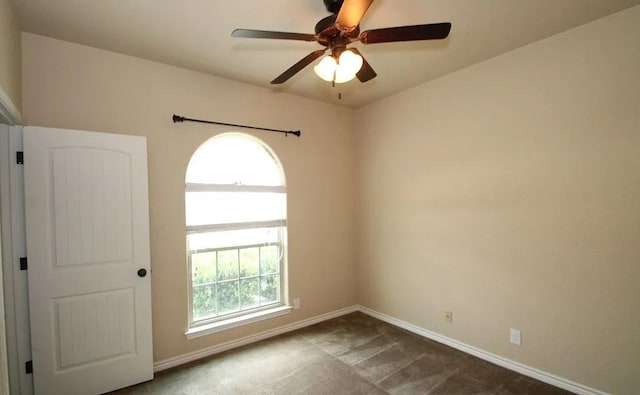 unfurnished room featuring a ceiling fan and baseboards