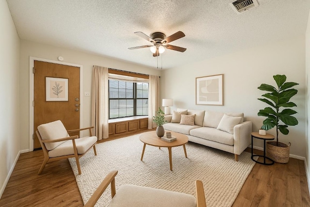 102 W Pheasant Dr, Austin, TX 78753 - living room featuring a textured ceiling, visible vents, baseboards, light wood-type flooring, and a ceiling fan