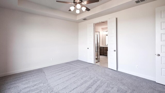 657 Bay Breeze Dr, Kyle, TX 78640 - empty room with light colored carpet, a ceiling fan, and a raised ceiling
