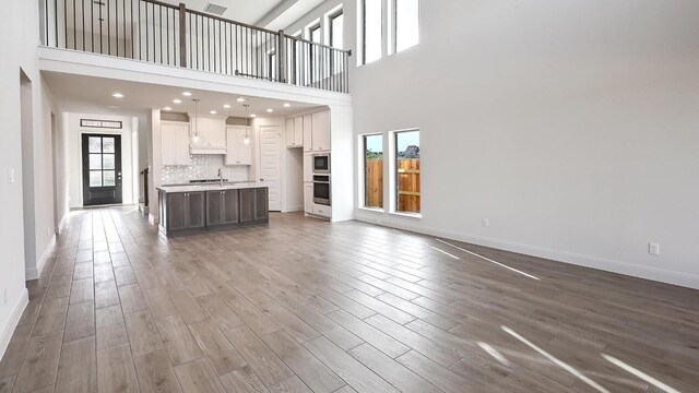 657 Bay Breeze Dr, Kyle, TX 78640 - unfurnished living room with wood finished floors and a high ceiling