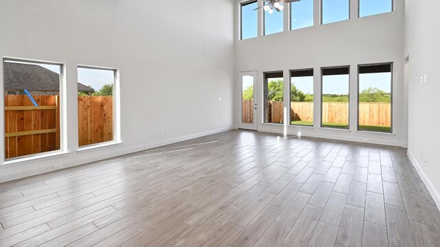 657 Bay Breeze Dr, Kyle, TX 78640 - unfurnished living room with a towering ceiling and wood finished floors