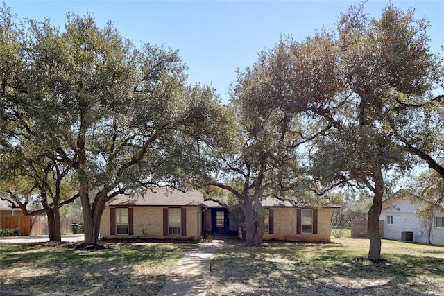 ranch-style home with brick siding, a front yard, and fence