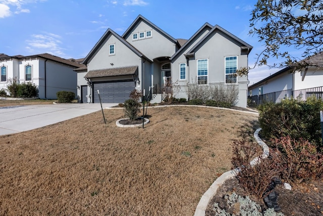 view of front of house featuring a garage, fence, concrete driveway, stucco siding, and a front yard