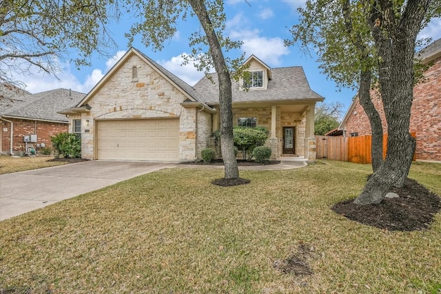 view of front of home featuring a garage, fence, stone siding, concrete driveway, and a front lawn