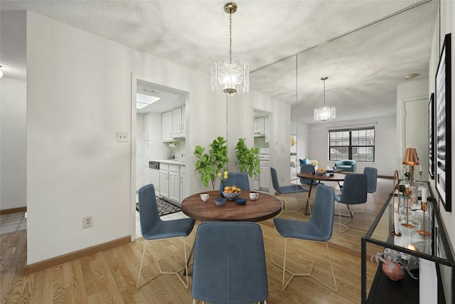 8210 Bent Tree Rd Unit 115, Austin, TX 78759 - dining space featuring a textured ceiling, light wood finished floors, and a chandelier
