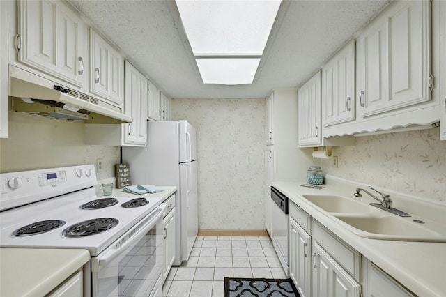 kitchen with white electric range oven, white cabinets, a sink, under cabinet range hood, and wallpapered walls