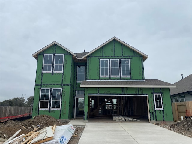 property in mid-construction with driveway, an attached garage, and fence