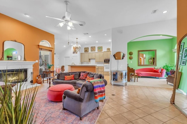 living room featuring a fireplace with raised hearth, light tile patterned flooring, recessed lighting, ceiling fan with notable chandelier, and visible vents