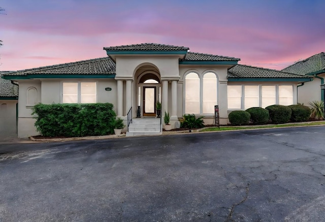 mediterranean / spanish-style home with a tile roof and stucco siding