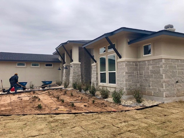 view of home's exterior featuring stone siding and stucco siding