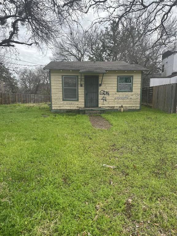 bungalow with a front yard and fence