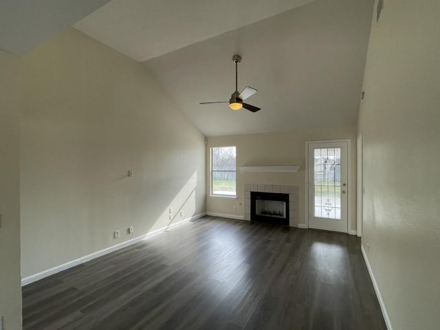 unfurnished living room with baseboards, dark wood finished floors, a ceiling fan, a tile fireplace, and high vaulted ceiling