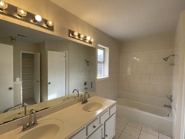 bathroom with double vanity, a sink, visible vents, and tile patterned floors