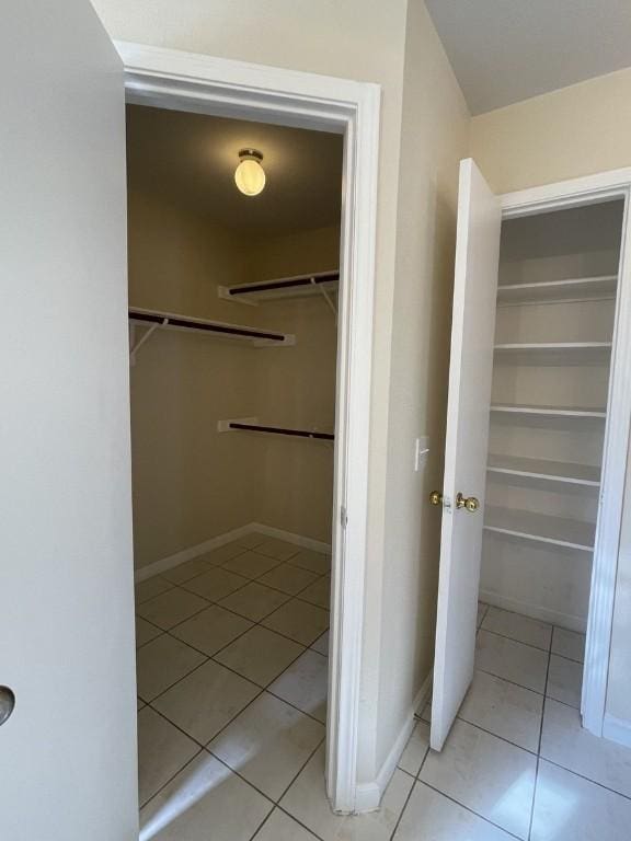 walk in closet with light tile patterned floors