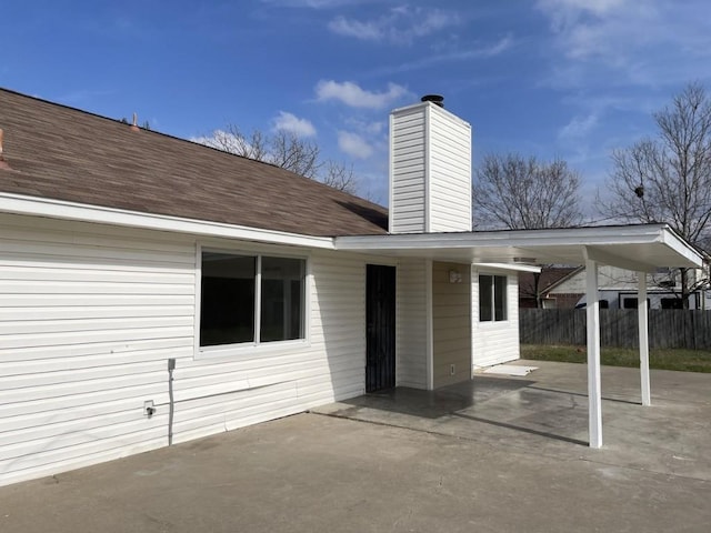 exterior space featuring fence and a carport