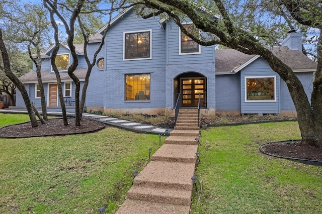 4704 Wild Briar Pass, Austin, TX 78746 - view of front of house with brick siding, a front yard, and a shingled roof