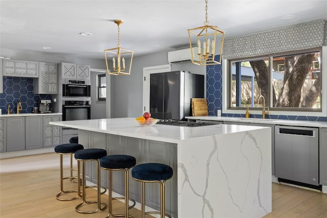 4704 Wild Briar Pass, Austin, TX 78746 - kitchen with stainless steel appliances, a chandelier, a wall mounted AC, backsplash, and recessed lighting