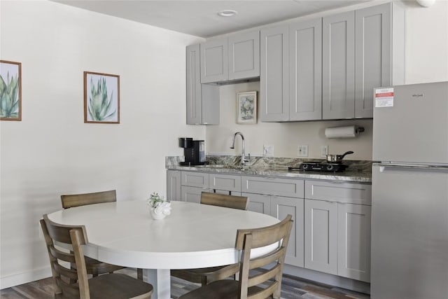 4704 Wild Briar Pass, Austin, TX 78746 - kitchen with freestanding refrigerator, a sink, gray cabinetry, and dark wood finished floors
