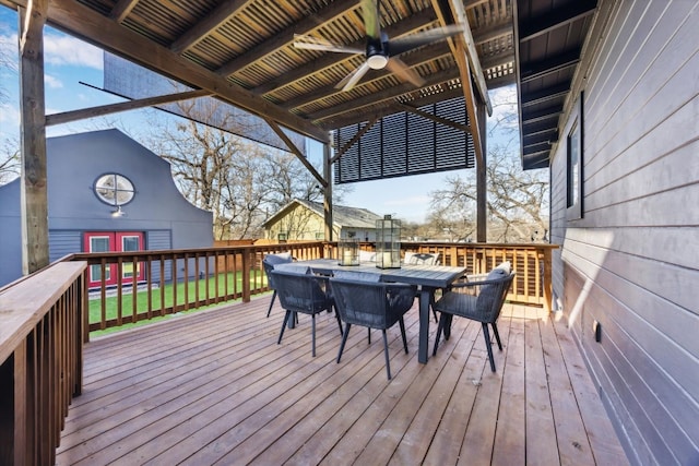 deck with an outbuilding, outdoor dining area, and a ceiling fan