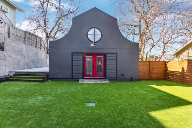 view of outbuilding featuring a fenced backyard, an outbuilding, and french doors