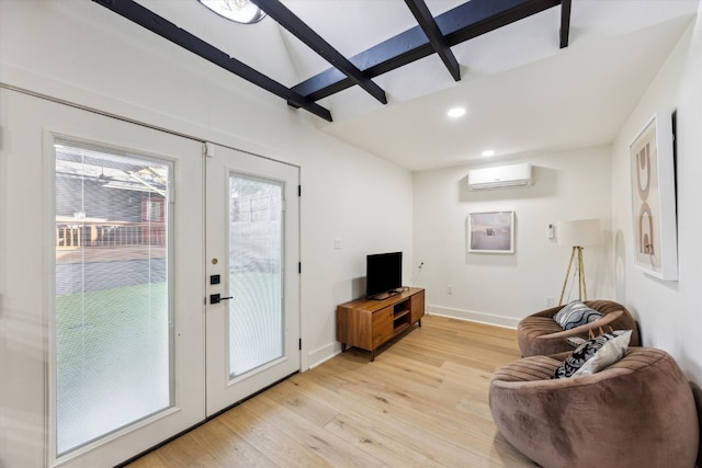 living room featuring baseboards, french doors, a wall mounted air conditioner, and light wood-style floors