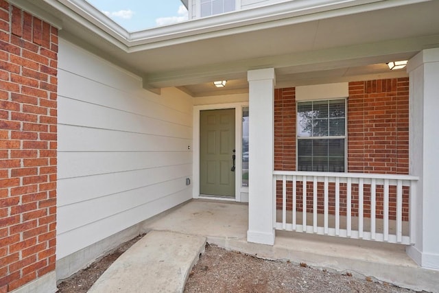 114 Challenger, Kyle, TX 78640 - doorway to property featuring covered porch and brick siding