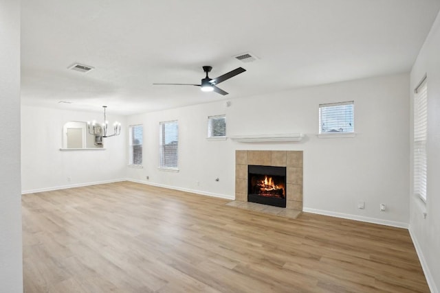 114 Challenger, Kyle, TX 78640 - unfurnished living room featuring a chandelier, light wood-style flooring, a fireplace, baseboards, and a ceiling fan