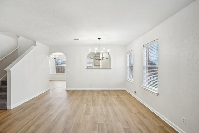 114 Challenger, Kyle, TX 78640 - unfurnished dining area with a chandelier, light wood-style floors, plenty of natural light, and baseboards