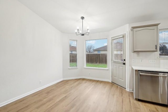 114 Challenger, Kyle, TX 78640 - unfurnished dining area with light wood finished floors, a chandelier, healthy amount of natural light, and baseboards