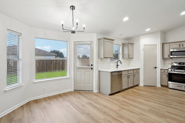 114 Challenger, Kyle, TX 78640 - kitchen with stainless steel appliances, gray cabinetry, backsplash, light wood finished floors, and recessed lighting