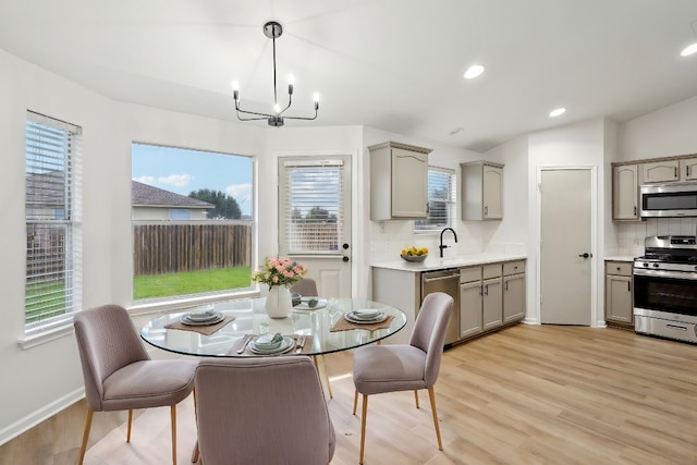 dining room with baseboards, recessed lighting, light wood-type flooring, and an inviting chandelier