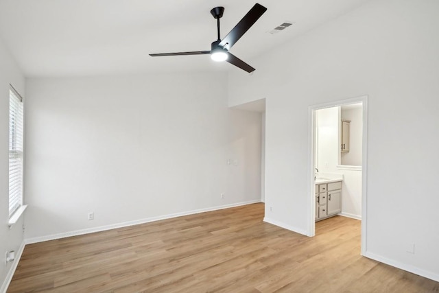 114 Challenger, Kyle, TX 78640 - unfurnished bedroom with light wood-type flooring, baseboards, ensuite bathroom, a ceiling fan, and a high ceiling