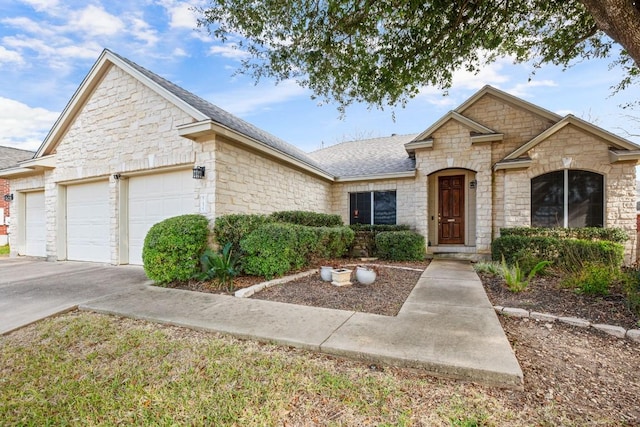 19907 Kennemer Dr, Pflugerville, TX 78660 - view of front facade with an attached garage, stone siding, driveway, and a shingled roof